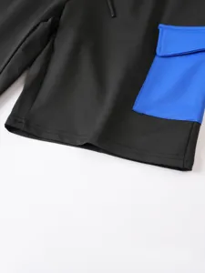 Primo piano dettagliato di pantaloncini cargo maschili neri con tasca blu in evidenza.