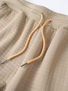 Waffle knit casual pants waistband and adjustable drawstring detail closeup, comfortable fabric.