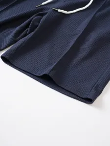 Men waffle knit shorts detail view, premium dark blue fabric with adjustable white drawstring.