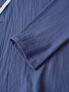 Gros plan de la manche de chemise à capuche en lin pour hommes avec boutons et texture.