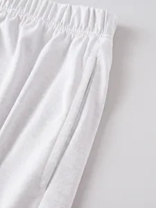 White casual shorts elastic waistband pocket detail closeup showing soft fabric texture.