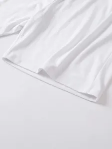 Close-up detail view of mens casual solid white short sleeve polo shirt fabric and hem stitch.