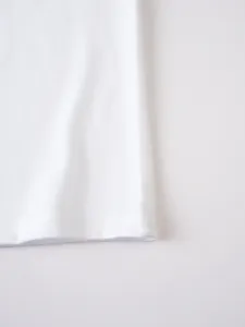 Dettaglio orlo in tessuto bianco con fine trama a doppia cucitura qualita abbigliamento.