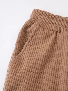 Detailaufnahme braun strukturierter Herrenshorts mit elastischem Bund und seitlicher Tasche.