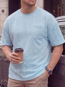 Detailopname van het lichtblauwe getextureerde t-shirt met korte mouwen en borstzak.