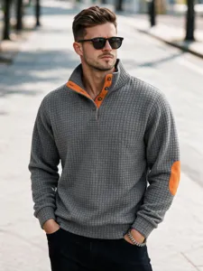 Jersey gris para hombre con cuello alto y coderas naranjas en contraste elegante.