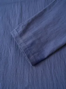 Close-up view of men's long-sleeve shirt cuff, showing fine textured fabric and neat stitching.