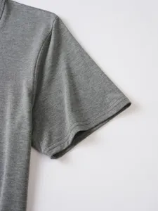 Close-up detail of gray mens t-shirt sleeve, fine knit fabric texture and neat stitching.