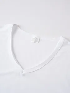 Close-up detail of white V-neck t-shirt collar showing size and material label inside.