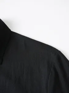 Men's black casual shirt detail close-up showing fine collar and shoulder stitching quality.