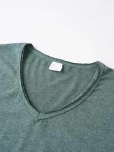 Men's v-neck t-shirt collar detail showing soft heather green fabric texture and label.