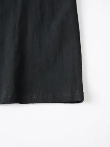 Close-up detail of black fabric hem and stitching for men's casual long sleeve shirt.