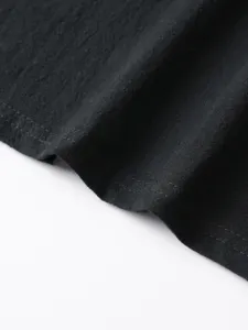 Close-up detail of black textured long-sleeve shirt fabric and neat double-stitching hem.