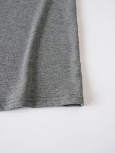 Close-up detail shot of grey knit fabric and neat stitching for men's casual t-shirt hem.