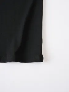 Tessuto nero texture e dettagli di cucitura puliti per abbigliamento uomo, primo piano.