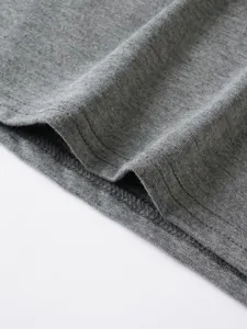 Grey cotton t-shirt hem detail, soft knit fabric with neat stitching close up view.