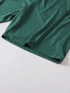 Detailed view of the dark green men's long sleeve T-shirt hem, showing premium fabric texture.