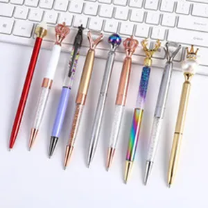 Detailed view of luxury metal ballpoint pens with creative crystal and crown toppers