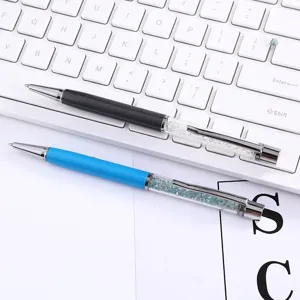 Detailed macro view of elegant metal ballpoint pens with shimmering crystal decoration.