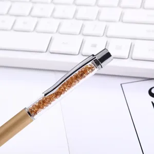 Detailed macro view of a luxury gold metal ballpoint pen filled with amber crystals