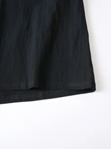 Gros plan sur les détails de l'ourlet de chemise casual en coton et lin noir avec couture.