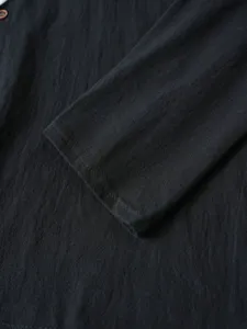 Vue de détail rapprochée de la manche de la chemise en coton et lin noir pour homme.