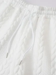 Close-up detail of textured fabric white shorts with adjustable drawstring and metal tips.