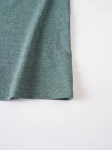 Dettaglio tessuto orlo abbigliamento tinta unita cotone verde per uomo collezione primaverile.