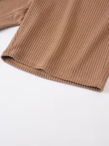 Detailansicht von braunen Rippstrick-Shorts, die feine Textur und saubere Nähte zeigen.