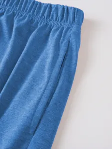Men's blue casual shorts detail close-up showing retro textured fabric and elastic waistband.