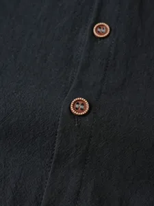 Gros plan detail de la patte de chemise décontractée pour homme et texture boutons bruns.