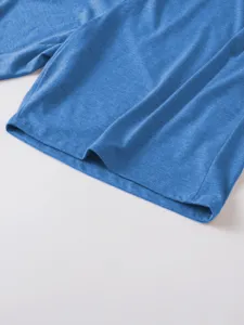 Close-up detail of the blue heather t-shirt fabric, hem, and stitching texture clearly shown.