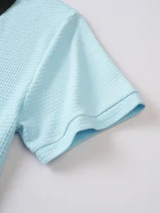 Mens waffle knit polo shirt sleeve detail, breathable texture short sleeve top close-up.