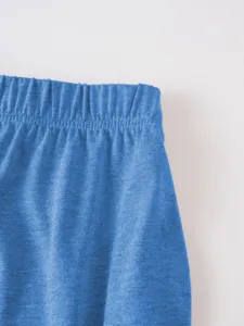 Close-up detail of blue stretch knitted fabric garment cuff or waistband showing fine texture.