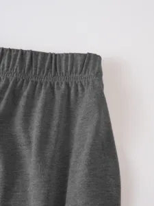 Close up detail view of dark gray knit apparel elastic waistband texture craftsmanship.