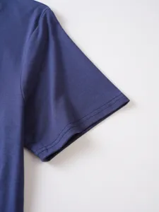 Primo piano del dettaglio manica corta blu scuro, cuciture fini su tessuto a tinta unita.