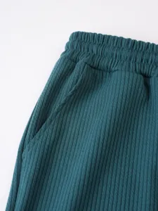 Nahaufnahme der Herren Freizeithose mit Rippstrick Textur elastischem Bund dunkelgruen