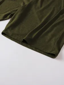 Close-up detail of the green short sleeve t-shirt hem, showing fine knit texture and neat stitching.