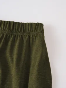 Detailed view of the elastic waistband and dark green soft fabric of the casual summer shorts.