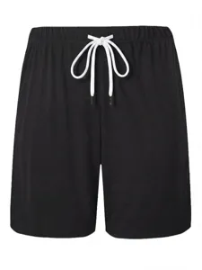 Detail view of black casual men's shorts featuring a contrasting white drawstring waistband.