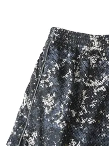 Primo piano sui dettagli dei pantaloncini sportivi in rete da uomo con mimetico e piping.