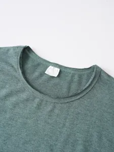 Dettaglio della scollatura della t-shirt mélange verde con cuciture e etichetta.