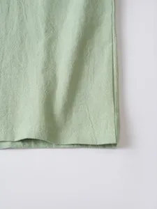Detail view of mens light green casual long sleeve shirt fabric hem texture close up
