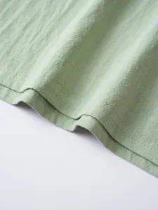 Detailed close-up view of light green men's casual solid long sleeve shirt fabric texture.