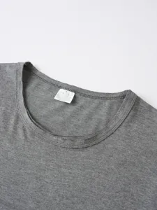 Primo piano dettagliato del collo e dell'etichetta interna della t-shirt grigia.