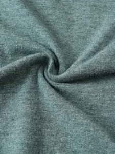 Close-up view of soft heather green knit fabric, showing fine texture and comfortable quality.