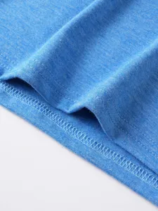 Primo piano dettaglio di orlo t-shirt uomo blu, cuciture fini e consistenza morbida.