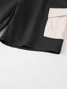 Vista dettagliata di pantaloncini cargo neri con tasca beige a contrasto e cuciture.