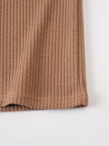 Close-up view of brown ribbed knit fabric showing texture and hem stitching detail.
