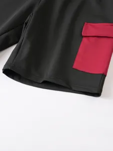 Primo piano sui dettagli dei pantaloncini cargo da uomo con tasca rossa a contrasto.